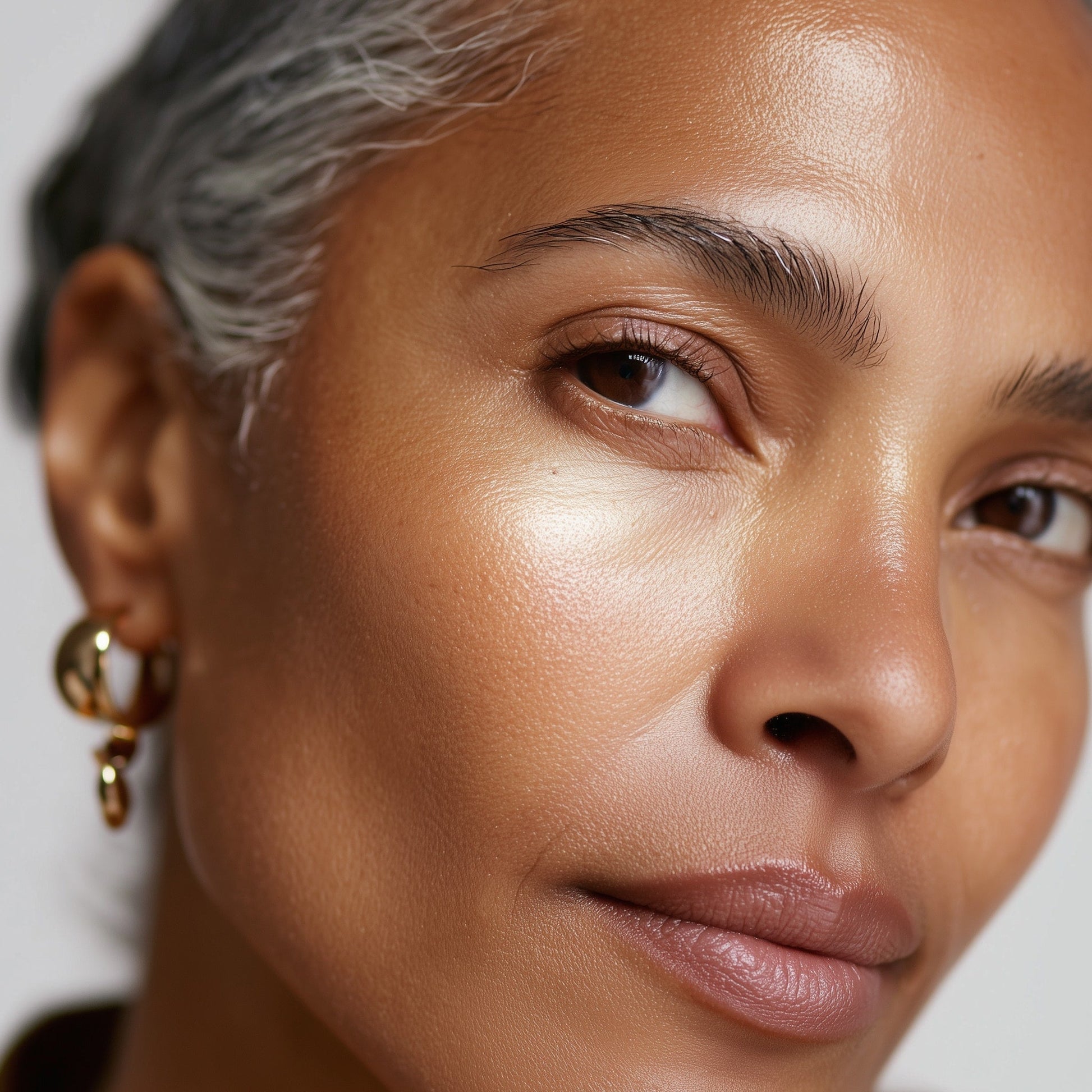 Close-up of a woman's face with a neutral background (Pink)