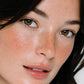 Close-up of a woman's face with freckles and brown eyes (Dark brown)