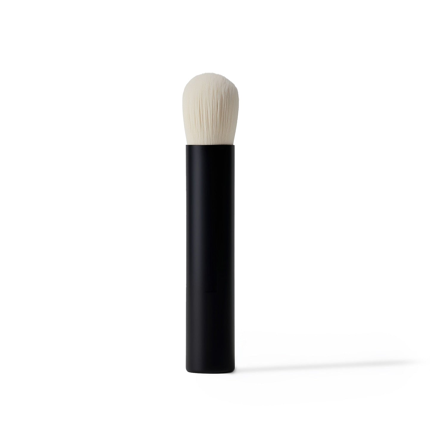 Makeup brush with black handle and white bristle head on a white background