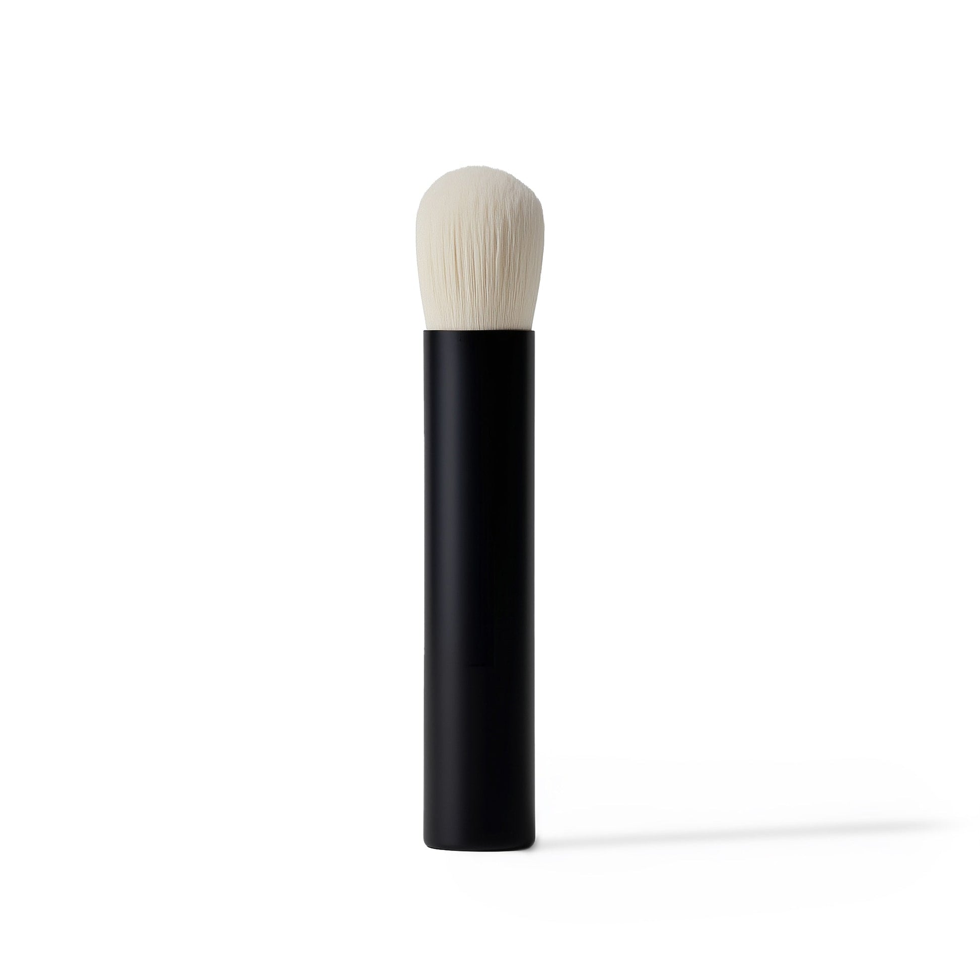 Makeup brush with black handle and white bristle head on a white background