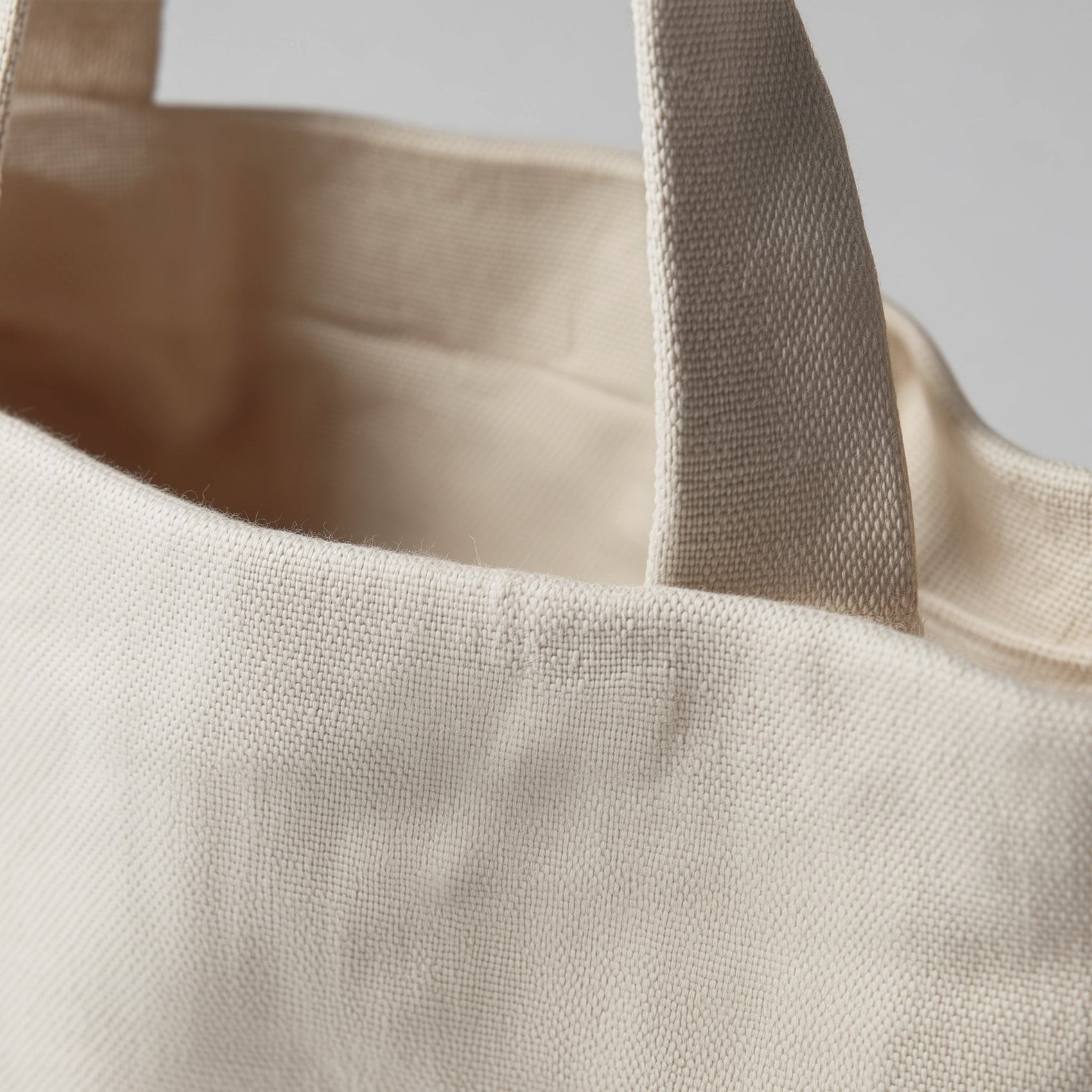 Close-up of a beige tote bag with a plain background