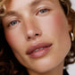 Close-up of a woman's face with a soft focus on her eyes and lips (Beige)