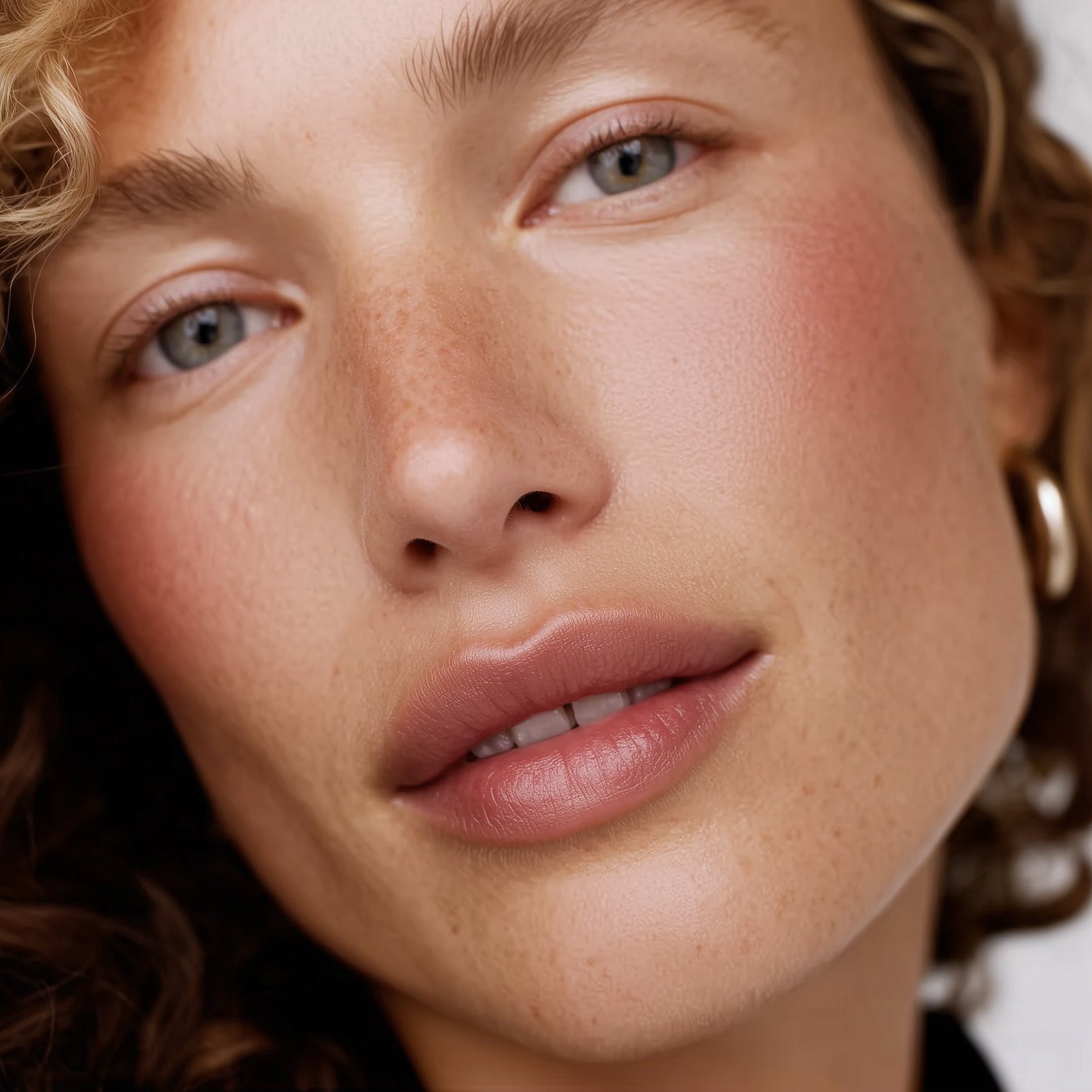 Close-up of a woman's face with a soft focus on her eyes and lips (Beige)