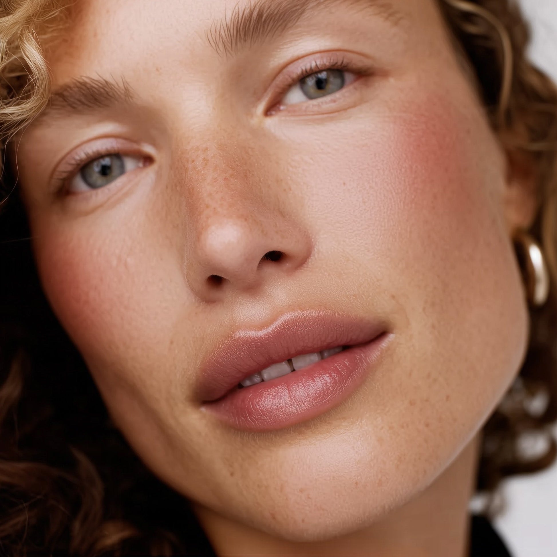 Close-up of a woman's face with a soft focus on her eyes and lips (Beige)