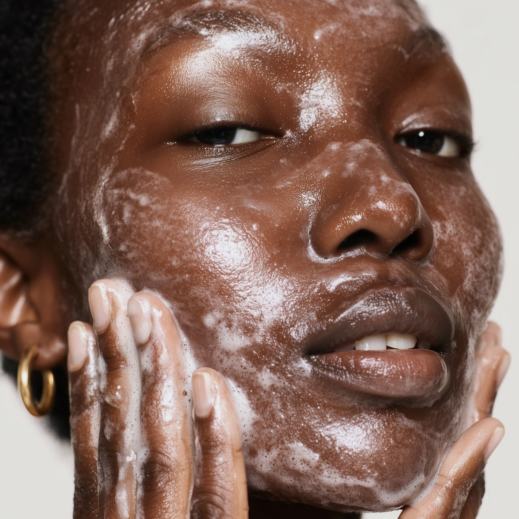 Close-up of a person applying a facial scrub to their face.