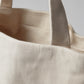 Close-up of a beige tote bag with a plain background