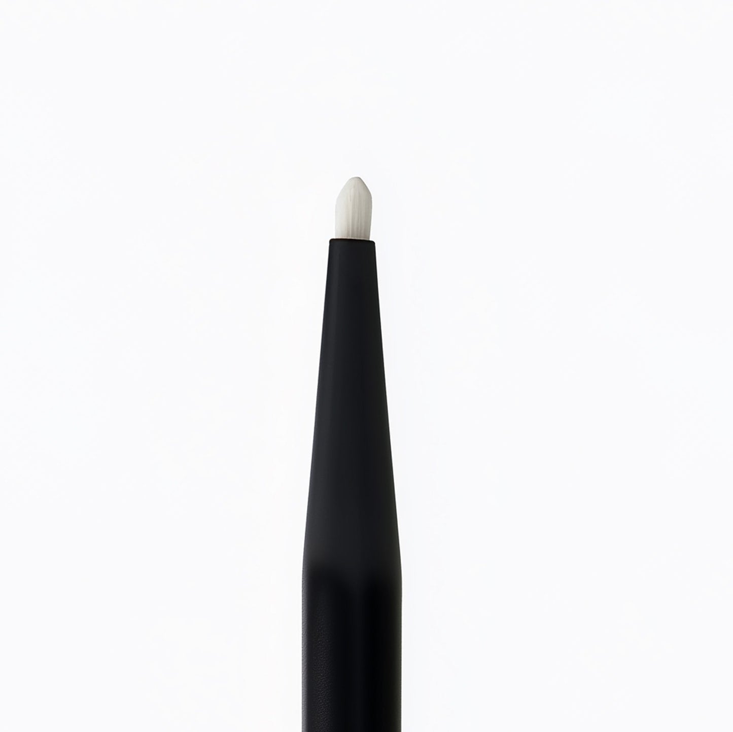 Black makeup brush with white bristle tip on a white background