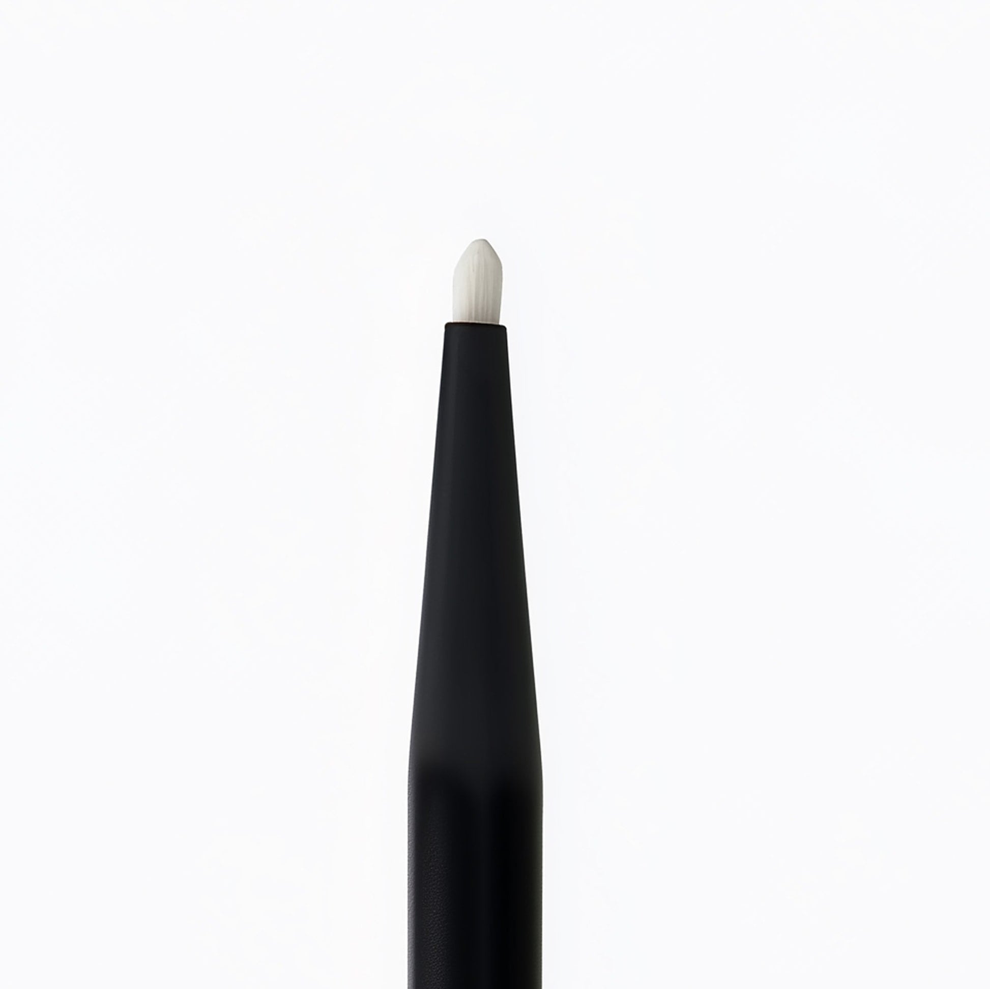 Black makeup brush with white bristle tip on a white background