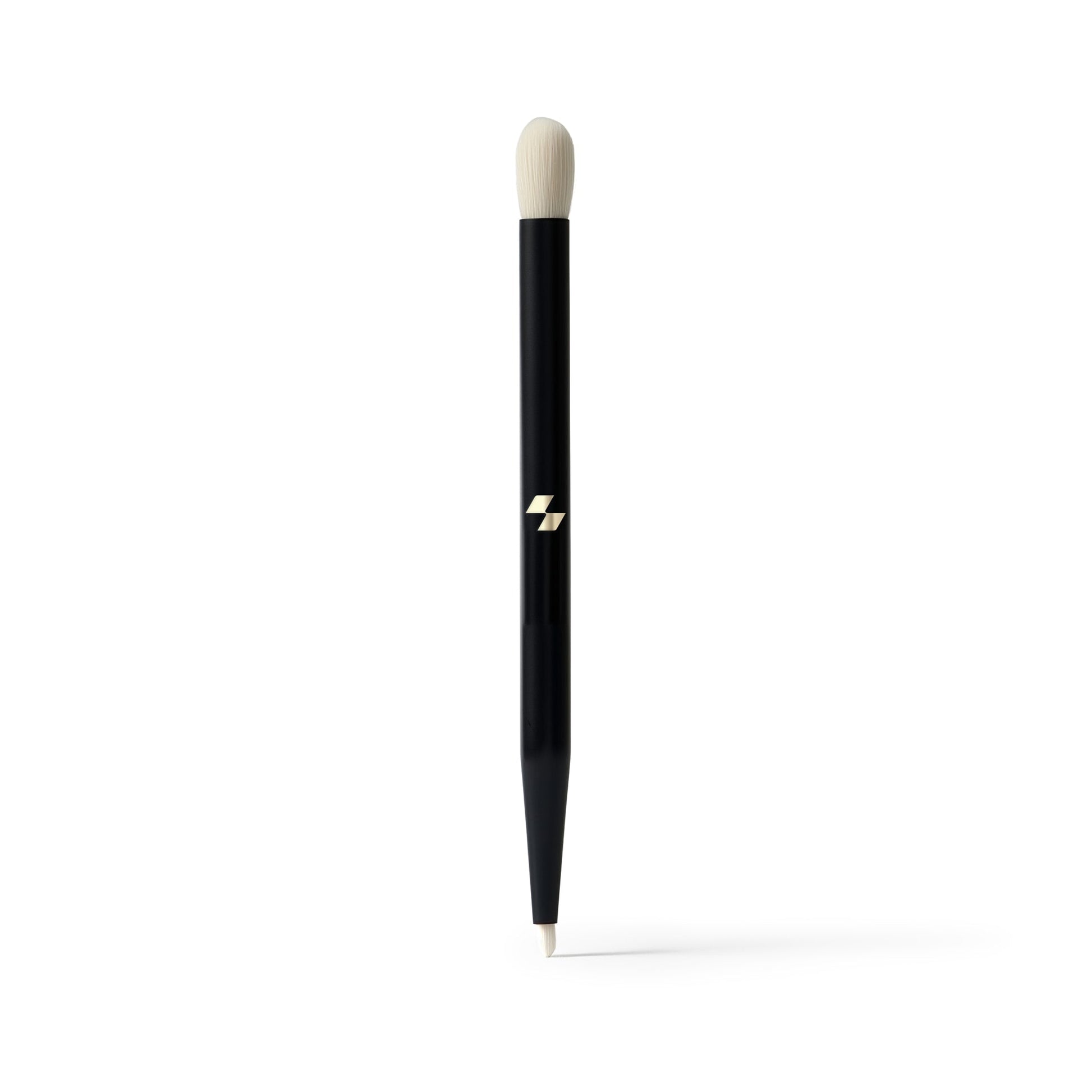 Black makeup brush with a white bristle tip on a white background