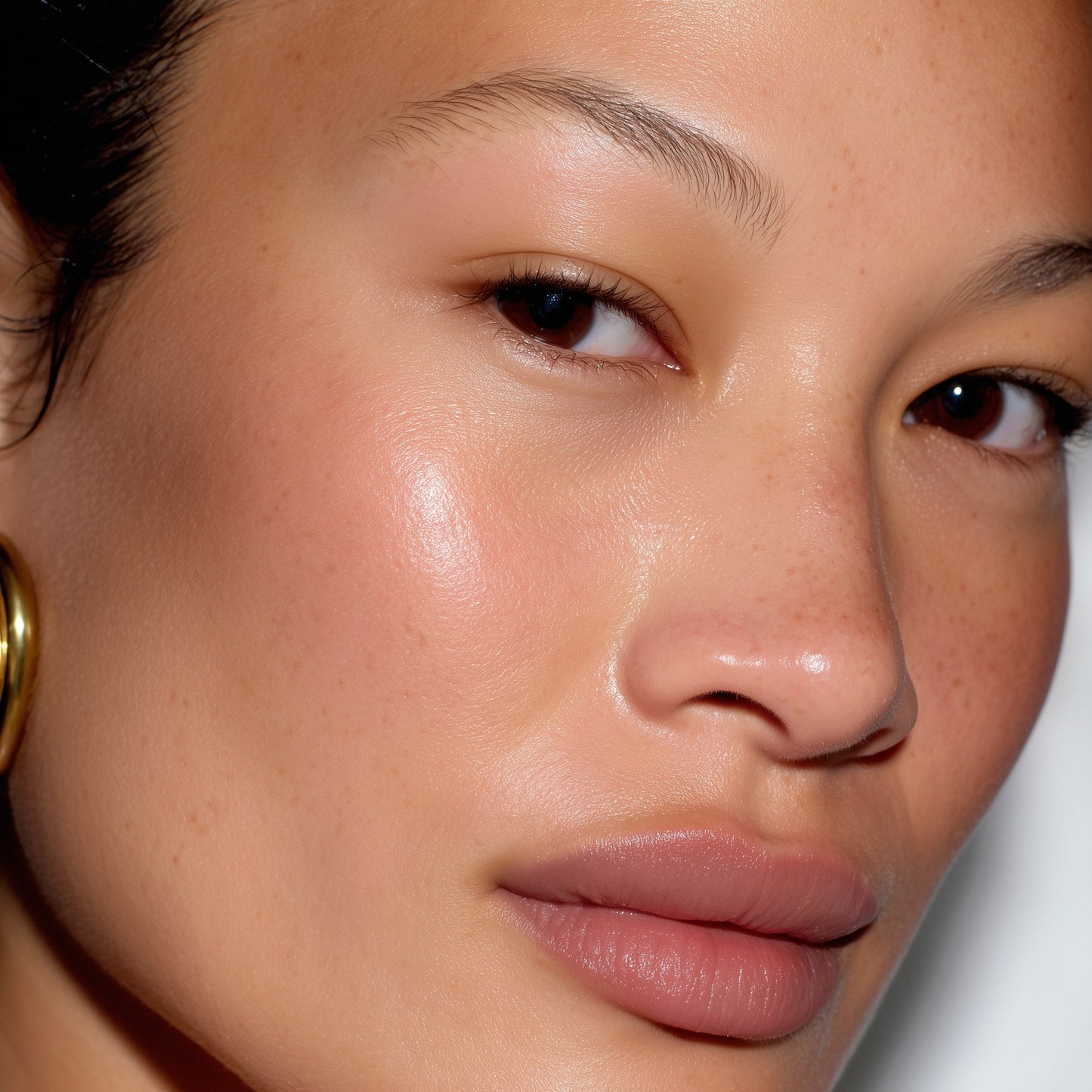 Close-up of a person's face with a neutral background (Brown)
