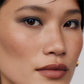 Close-up of a person's face with a neutral background (Violet)