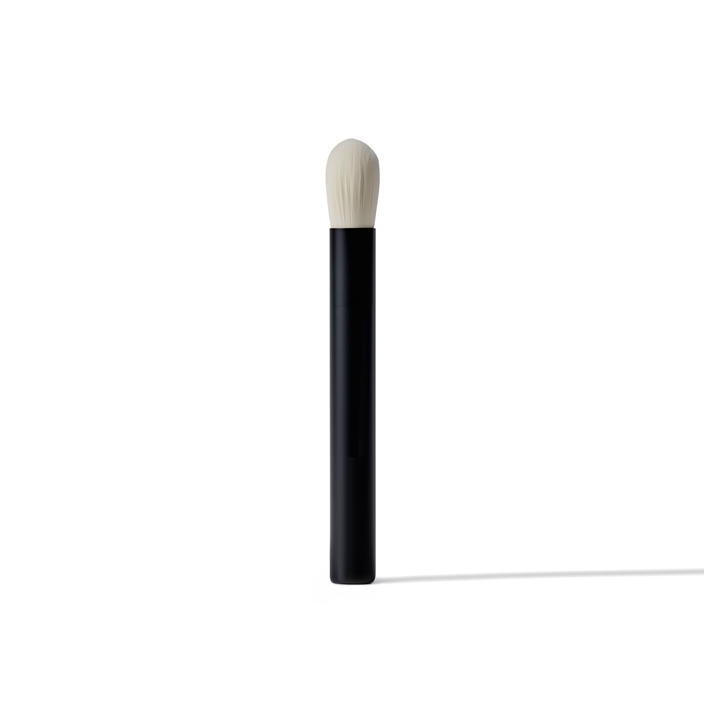Makeup brush with black handle and white bristle head on a white background