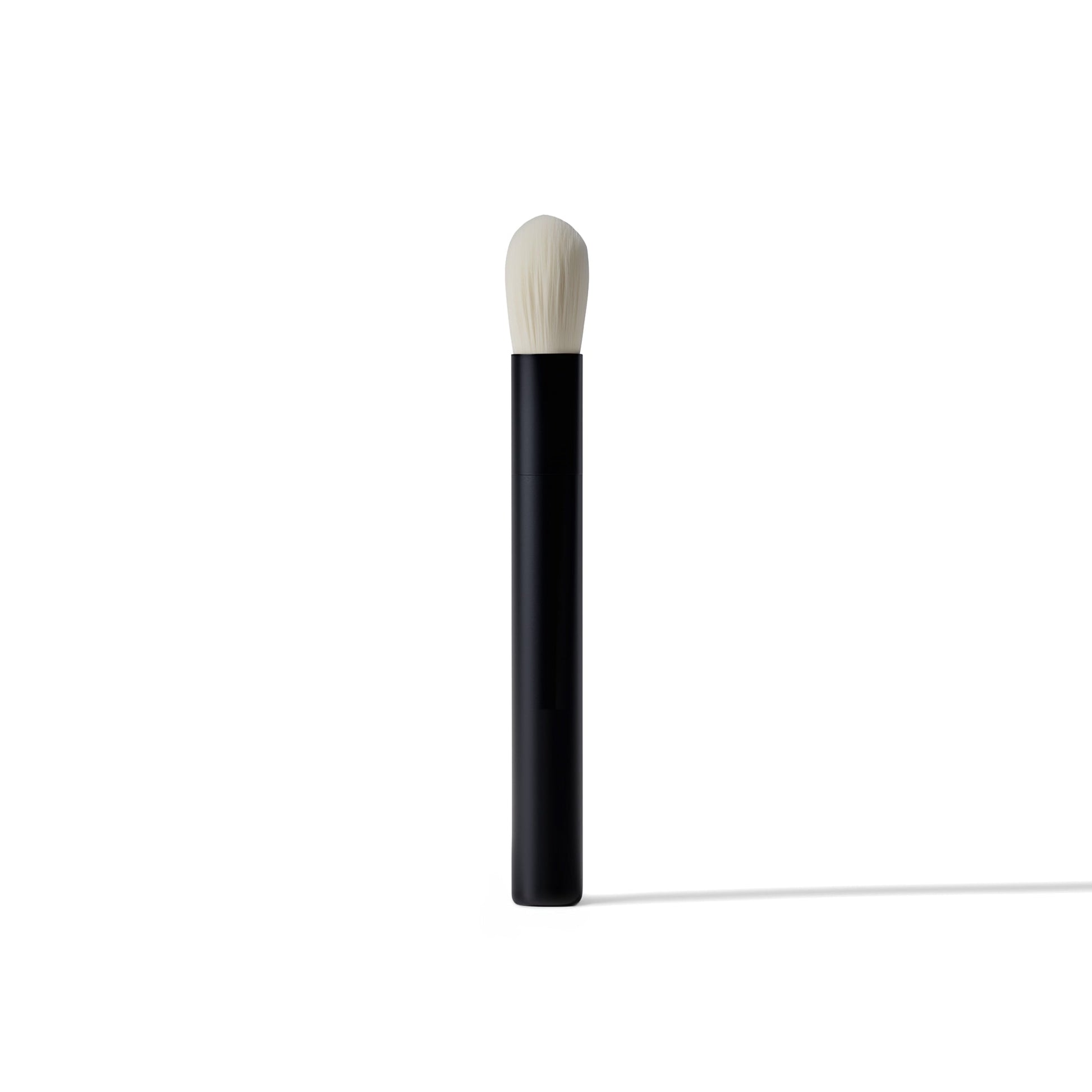 Makeup brush with black handle and white bristle head on a white background