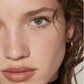 Close-up of a person's face with a gold hoop earring.