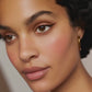 Close-up of a face featuring subtle peach-toned makeup and defined winged eyeliner.