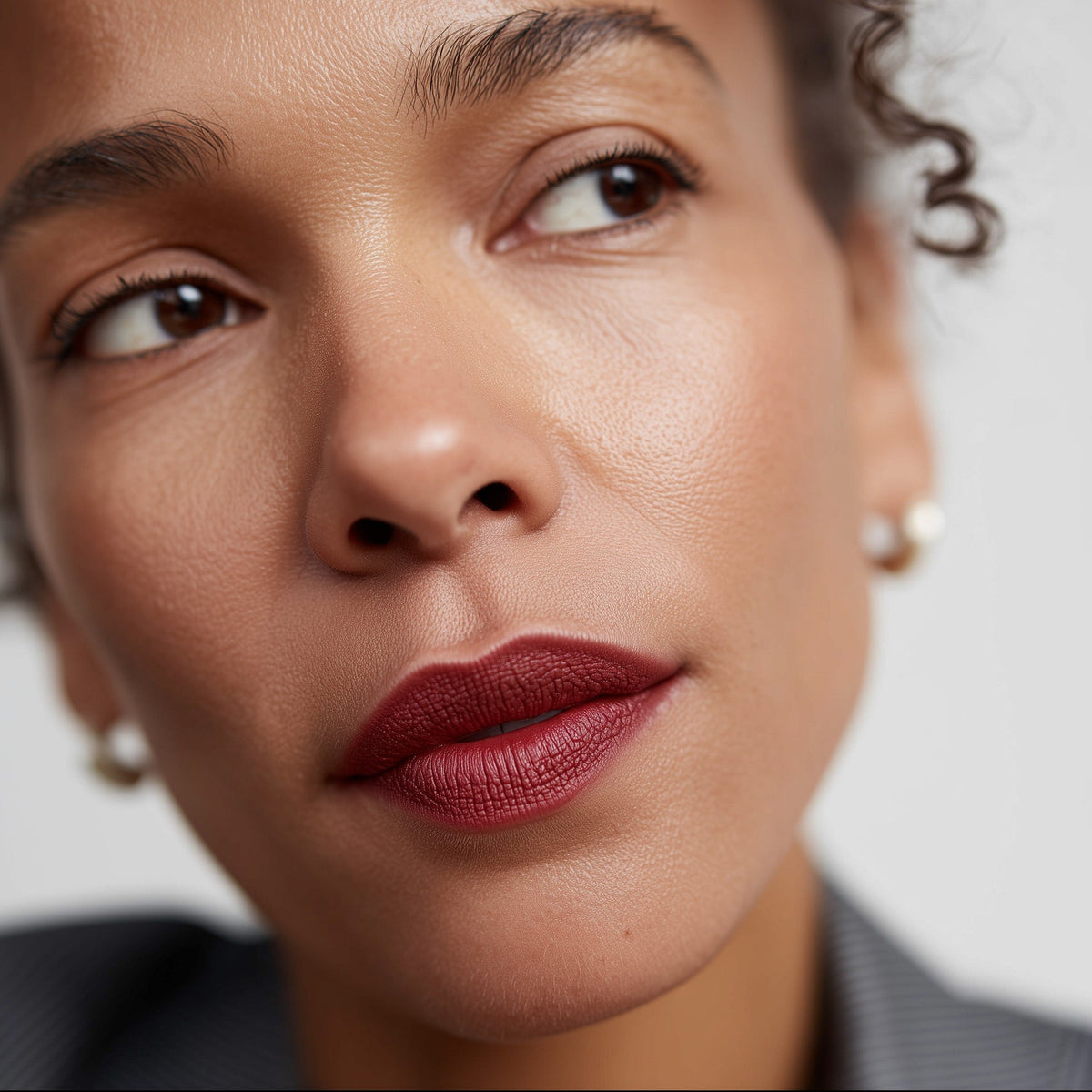 Close-up of a woman's face with a neutral background (Red)