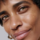 Close-up of a woman's face with a neutral expression on a gray background