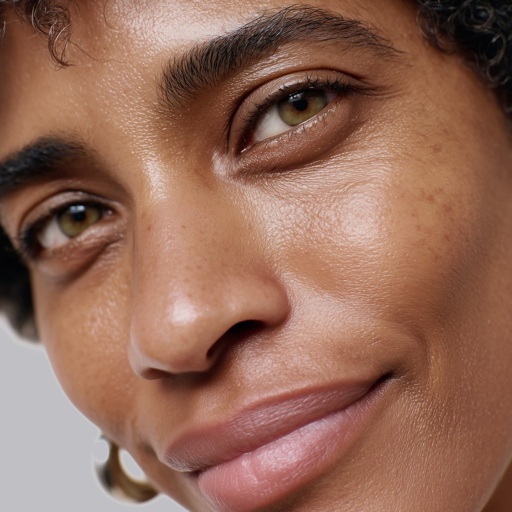 Close-up of a woman's face with a neutral expression on a gray background