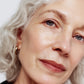 Close-up of a woman's face with gray hair and blue eyes (Natural)